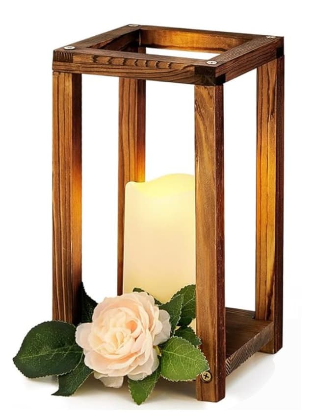 Wooden centerpiece measuring 5.5 inches long, 5.47 inches wide, and 10.59 inches high, featuring a candle holder and adorned with a faux flower and greenery, with the candle and greenery not included.