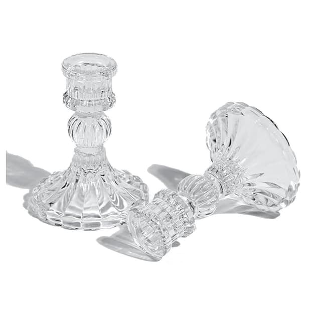 Clear glass candlestick holder, four inches tall.