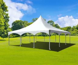 White high peak event tent set up on green grass under blue sky